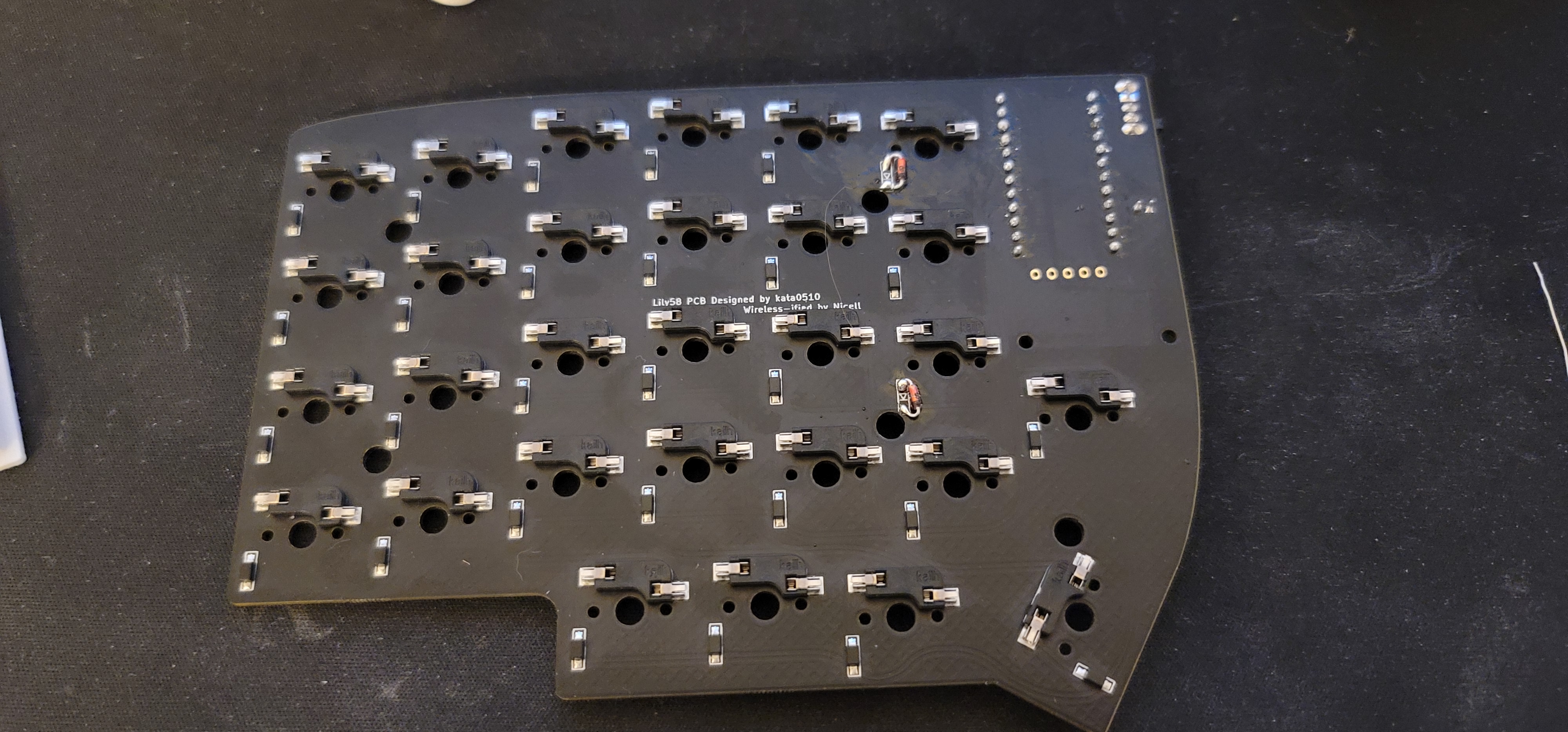 The bottom of the lily58 PCB with two through-hole diodes soldered in place of the surface mount ones